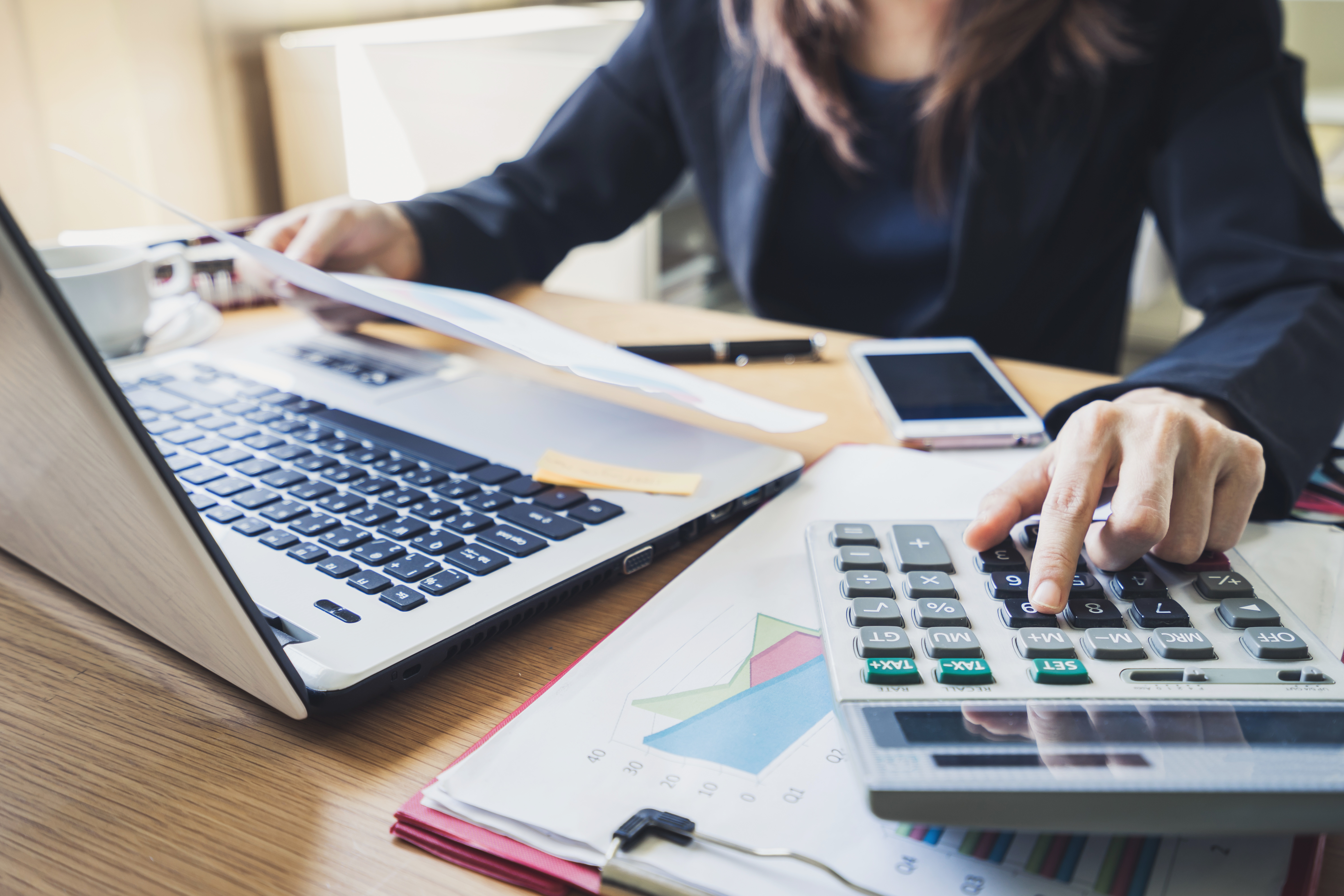 Business woman using a laptop and calculator